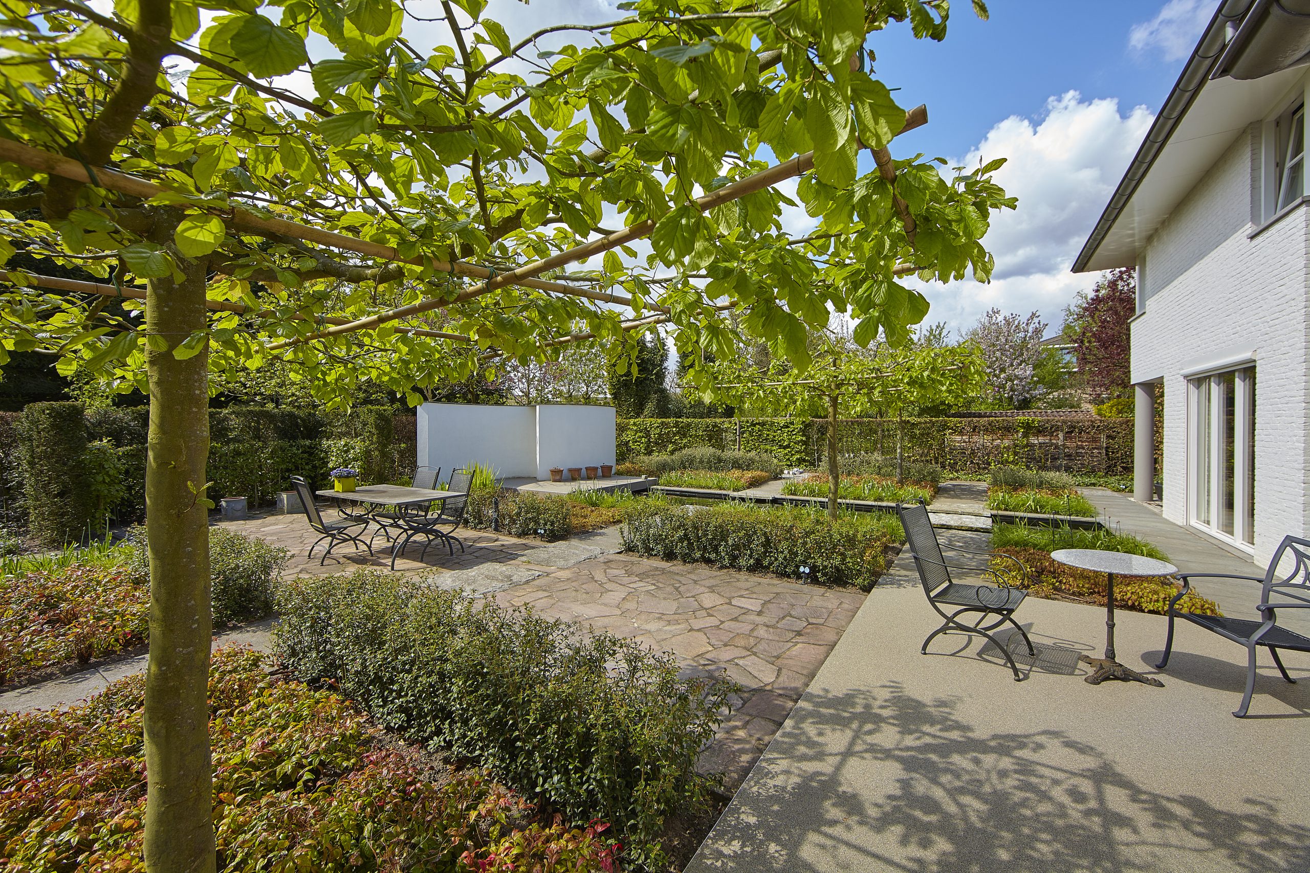 strakke moderne tuin met terrassen en koivijver