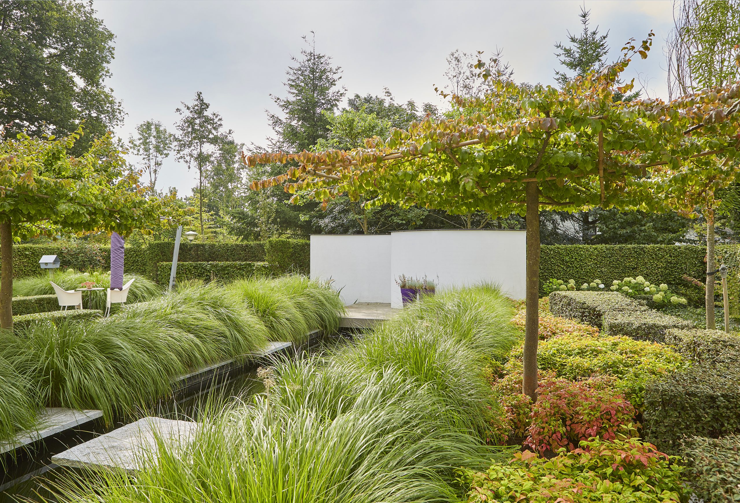strakke moderne tuin met terrassen en koivijver